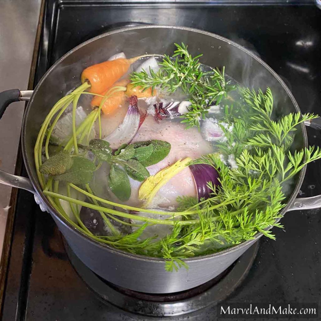 Boiling a chicken with herbs and veggies How to Boil a Whole Chicken by Marvel & Make at marvelandmake.com